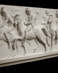 photo of plaster cast relief sculpture of men on horses against black background