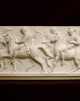 photo of plaster cast relief sculpture of men on horses against black background