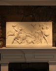 photo of plaster cast relief of men, some with armor, horses, and a dog over a fireplace with a stone wall