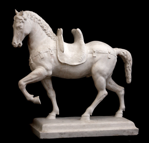 Photo of a sculpture of a plaster horse on a black background