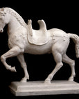 Photo of a sculpture of a plaster horse on a black background