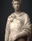 photo detail of plaster cast sculpture of male figure, namely Saint George, standing in armor and resting shield in front, on dark gray background