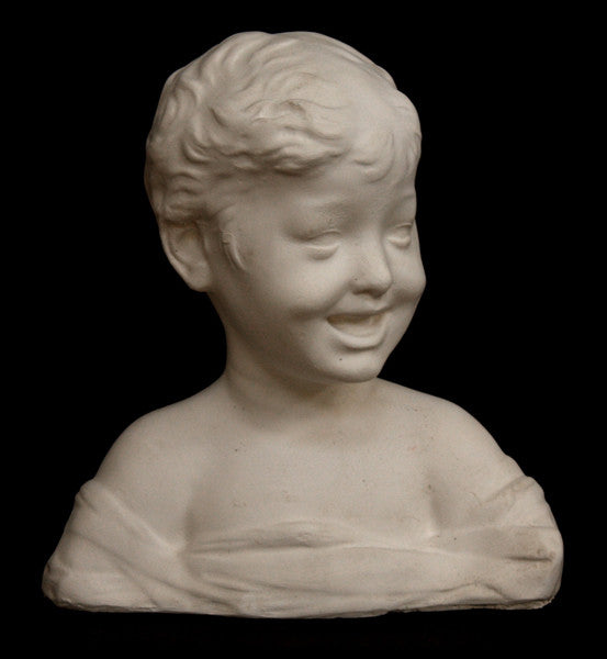 photo of white plaster cast sculpture bust of boy with open mouth, laughing, short hair, and clothes below his shoulders against a black background