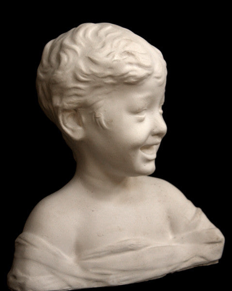 photo of white plaster cast sculpture bust of boy with open mouth, laughing, short hair, and clothes below his shoulders against a black background