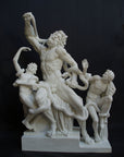 photo with black background of plaster cast sculpture of partially nude male figure, namely Laocoon, and two nude young men being attacked by serpents which twist in and out of the three figures