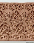 photo of plaster casts of architectural ornament with geometric lines and leaf patterns in terracotta color against white background