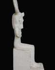 photo with black background of plaster cast sculpture of Egyptian mummy seated