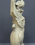 Photo with gray background of plaster cast sculpture of imaginary seated winged lion